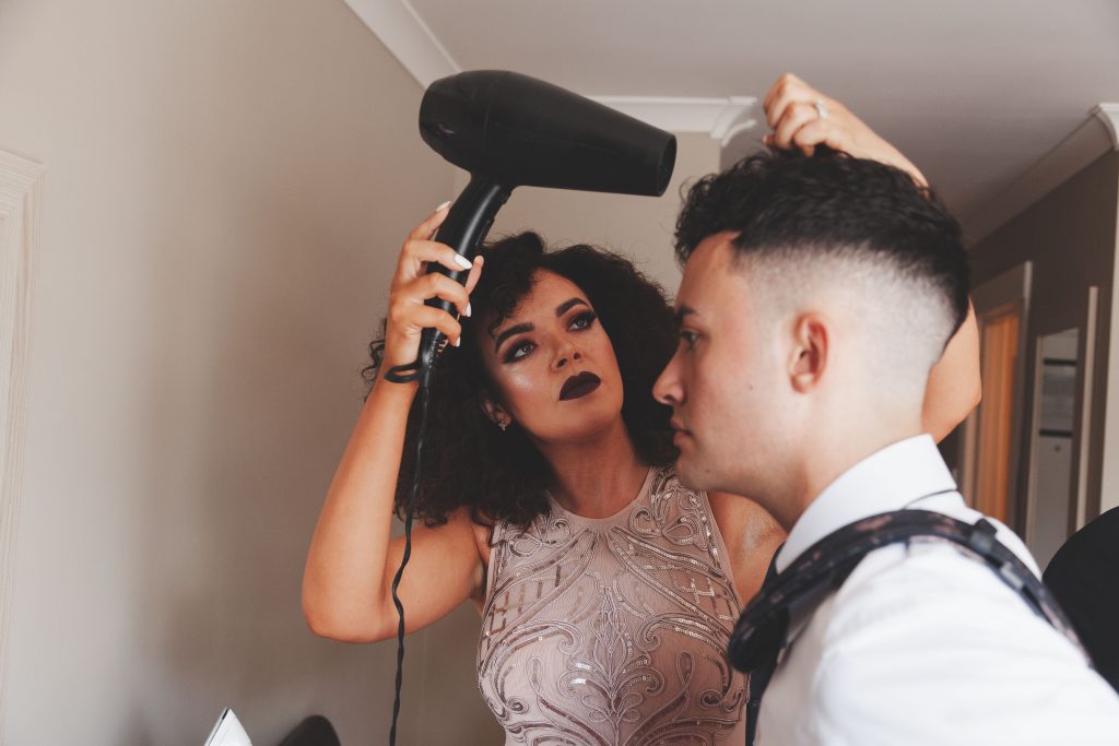 Jodi and Jade wedding photography Dublin Wexford sister blow drying grooms hair
