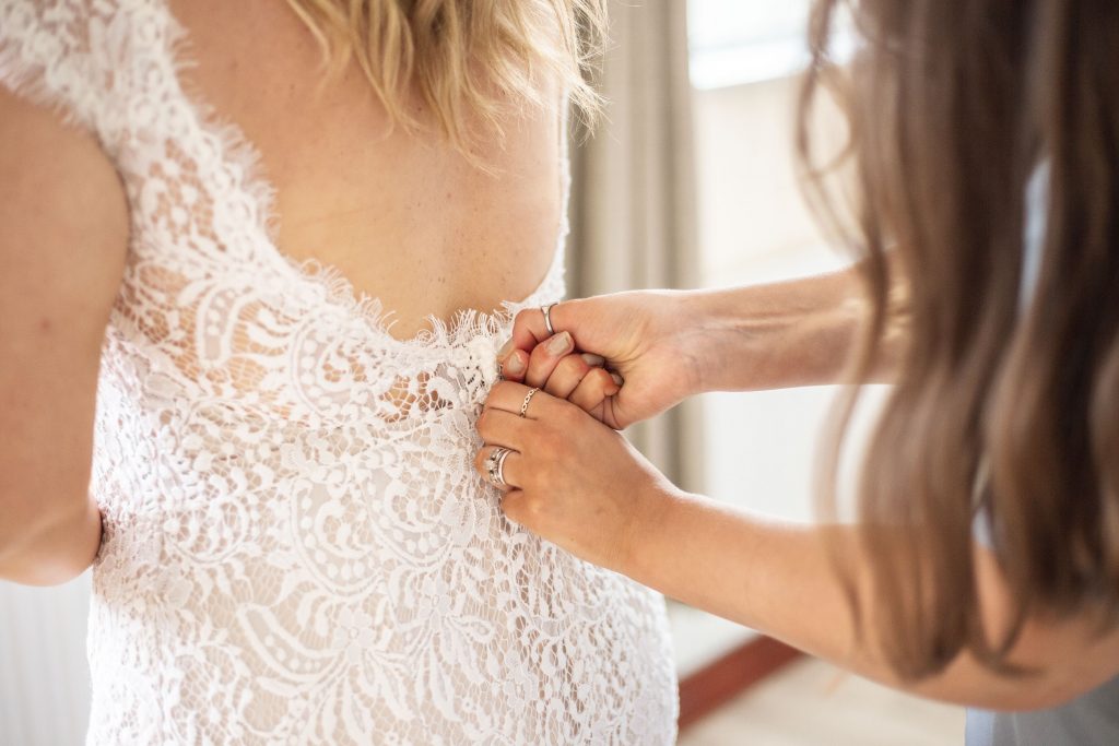 Jack and Katie Antrim elopement bride getting zipped up by bridesmaid