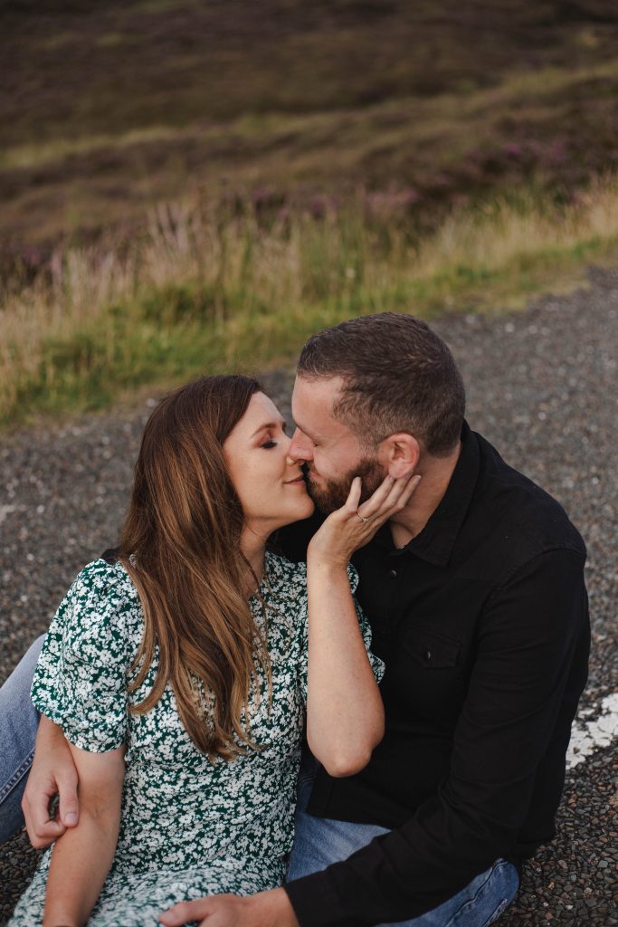Anna and Colm engagement photography in wicklow mountains sitting in the road cuddling