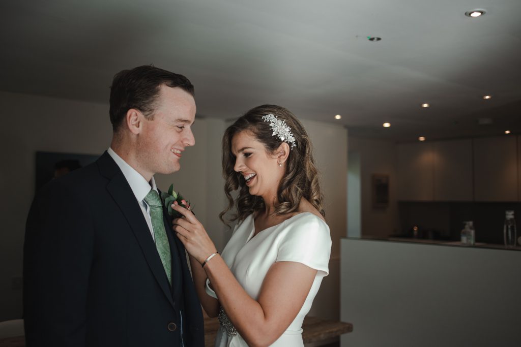 Gemma and Paddy New Ross Intimate wedding bride pinning boutonniere on groom