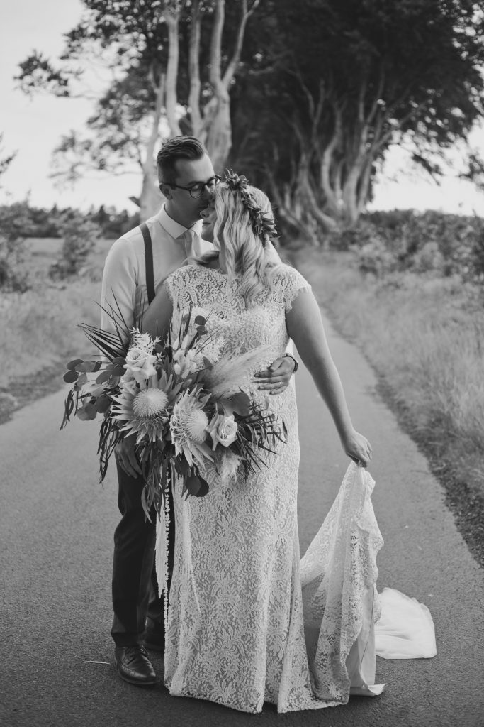 Jack and Katie Dark hedges Elopement wedding photography groom standing behind bride in staggered pose