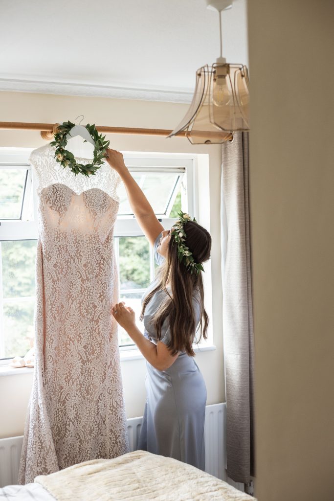 Jack and Katie Antrim elopement bridesmaid helping and hanging up wedding dress